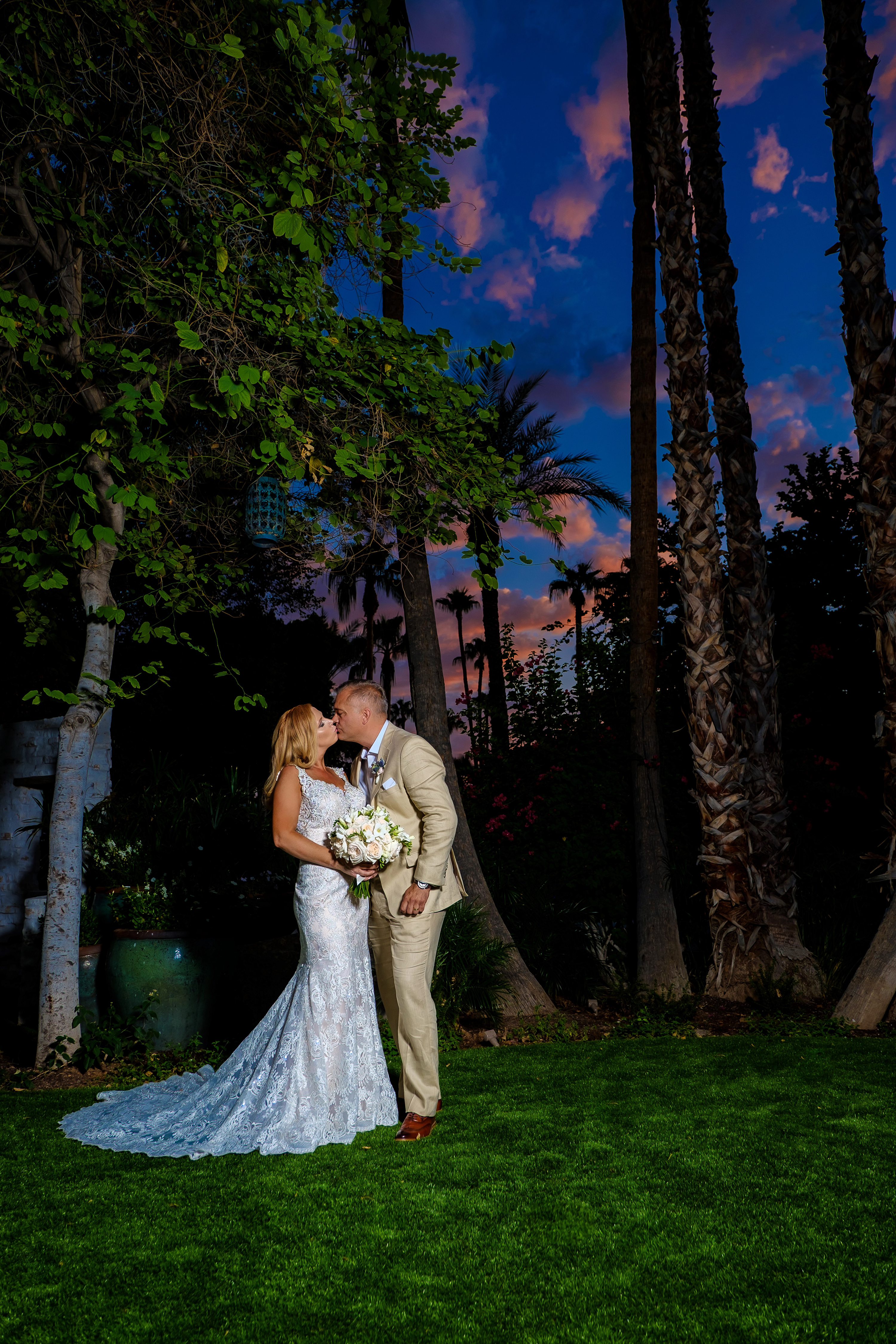 the scott resort & spa wedding,Fujifilm,Bride and groom kissing in front of palm trees with a sunset in the background at The Scott Resort