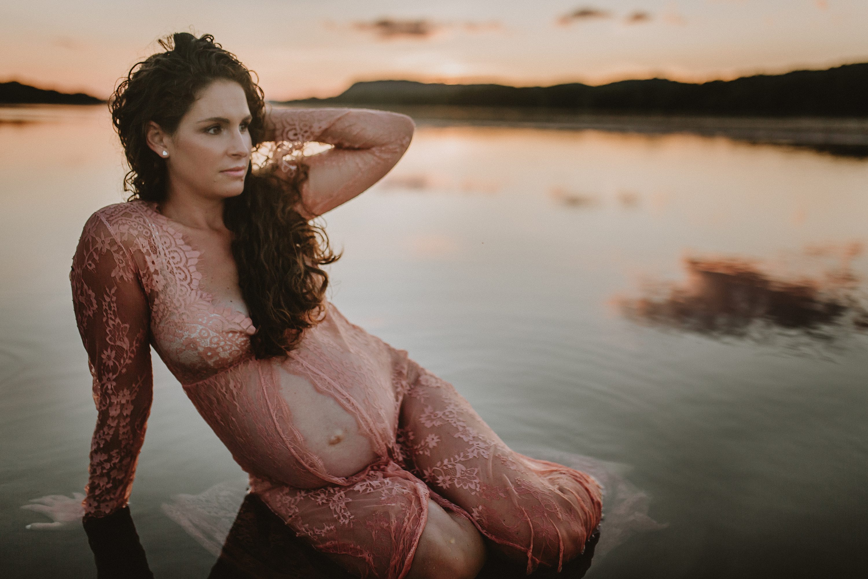 Maternity session by the river,Pregnant mother in a lace gown by the beach,PPregnant mother in a peach, lace gown by the water.,Pregnant mother in a long, lace gown holding her belly.,Pregnant woman in a peach gown near the river at sunset.