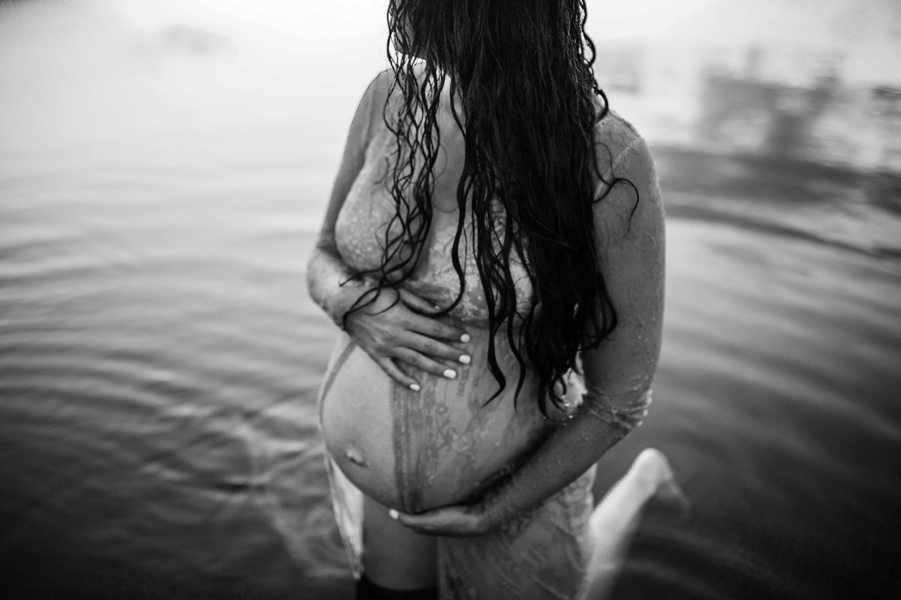 Maternity session by the river,Pregnant mother in a lace gown by the beach,PPregnant mother in a peach, lace gown by the water.,Pregnant mother in a long, lace gown holding her belly.,Pregnant woman in a peach gown near the river at sunset.