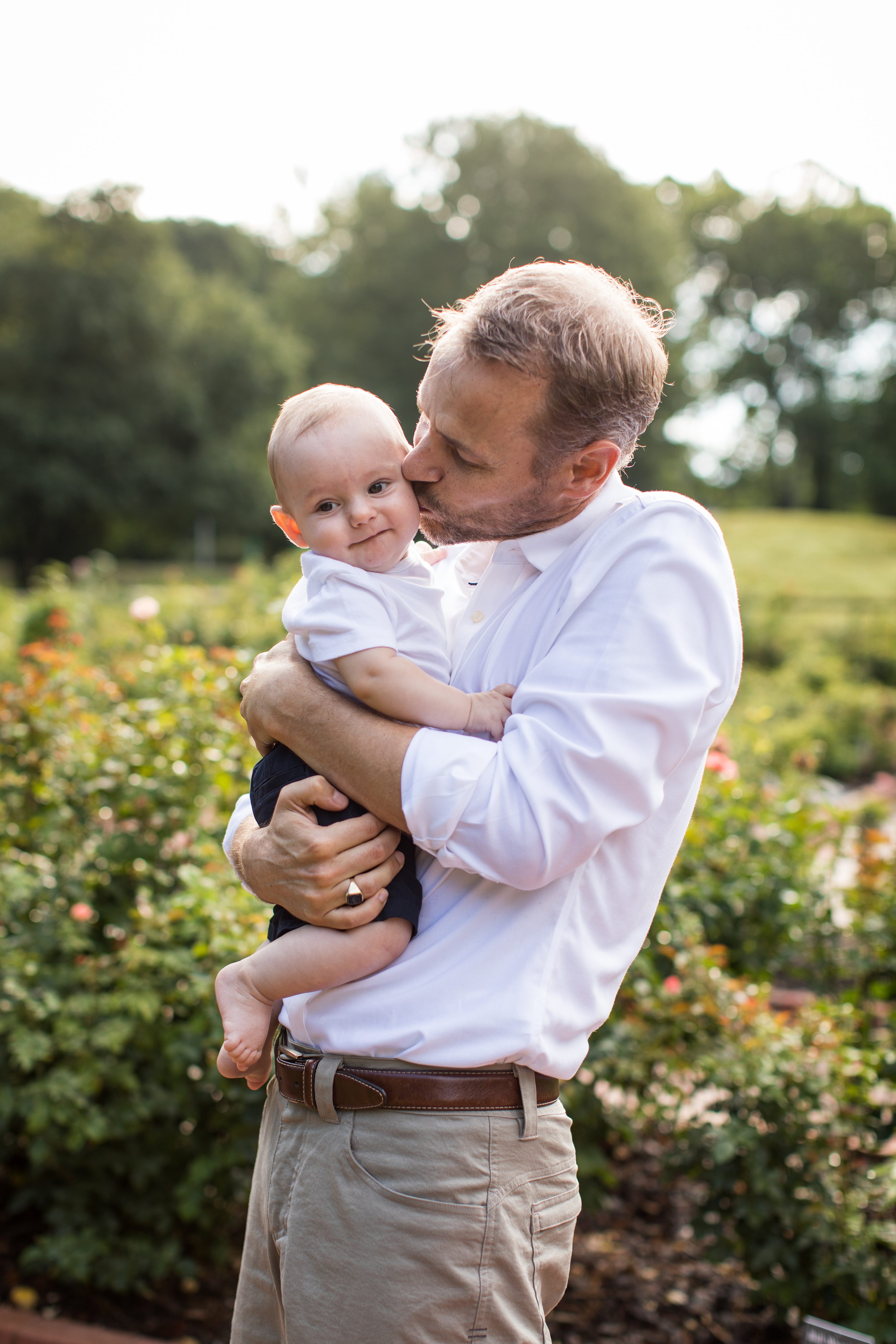 Raleigh Baby Photography,gene stroud rose garden park,dad kissing babys cheek,chapel hill baby photography