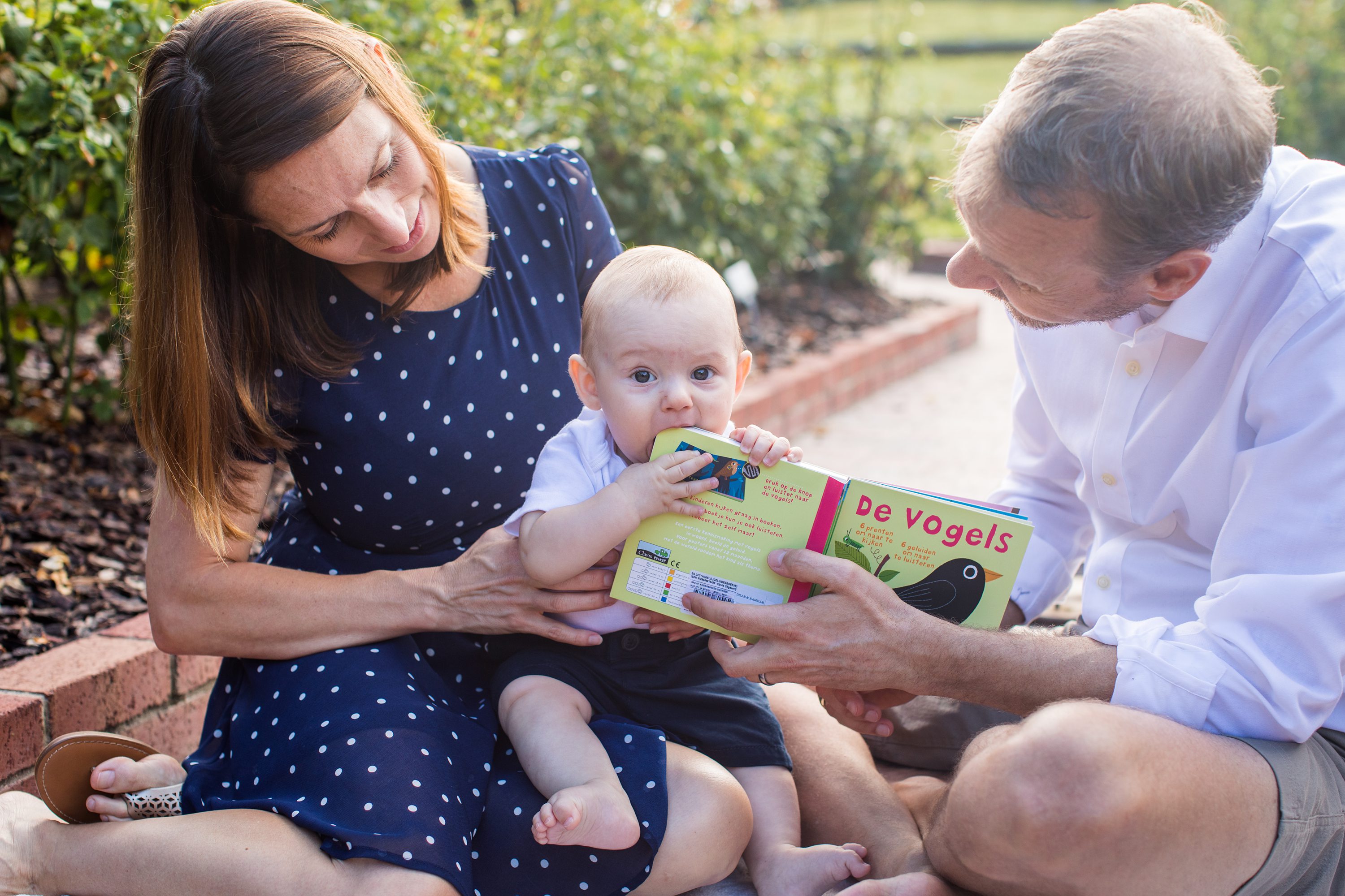 Baby Photos,baby chewing on book,6 month old baby,baby sitting with parents