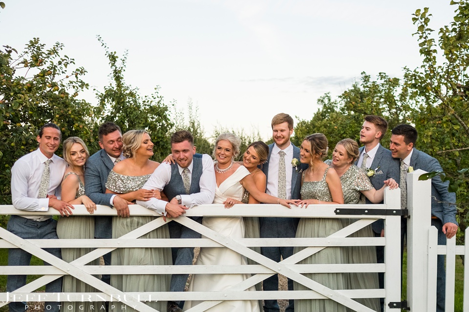 Villietrs Barn Recomended Wedding Photographer,Villiers Barn Weddings,Wedding Party Leaning on a white gate at Villiers Barn Wedding Venue
