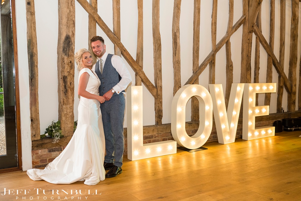Villiers Barn Wedding Venue,Summer Wedding,Bride and Groom next to a LOVE Sign