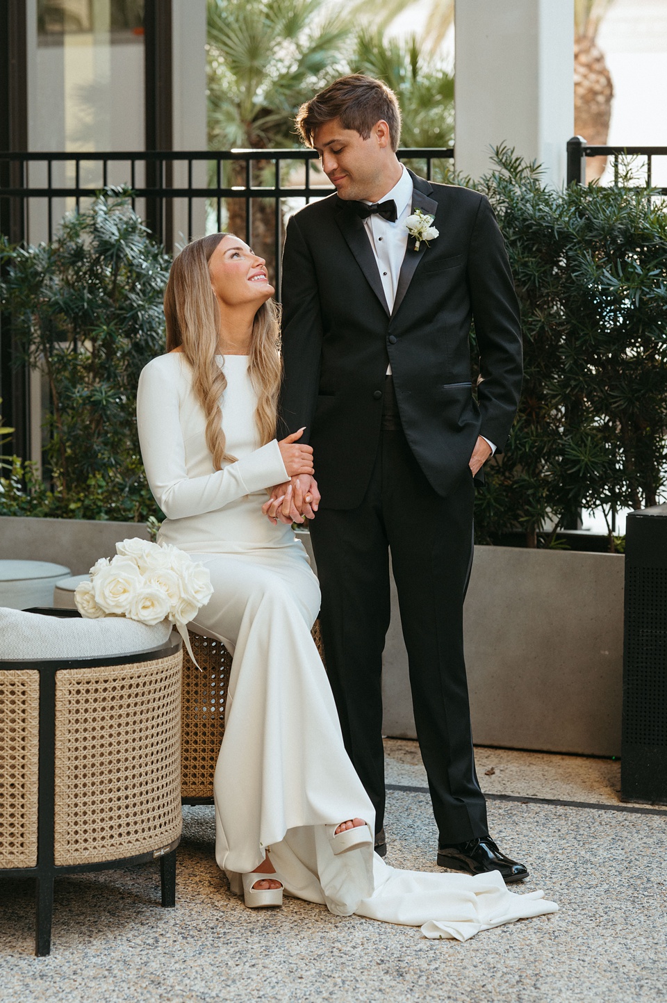 Bride Alexandra in her Vagabond Bridal gown holding a romantic bouquet by Leaf and Petal,Bride and groom exchanging vows in the courtyard of the Four Seasons New Orleans.