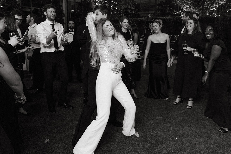 Bride Alexandra in her Vagabond Bridal gown holding a romantic bouquet by Leaf and Petal,The Four Seasons courtyard set up for an intimate outdoor wedding ceremony.