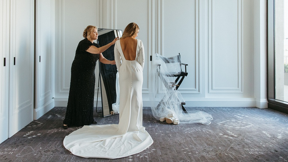 Bride Alexandra in her Vagabond Bridal gown holding a romantic bouquet by Leaf and Petal,The Four Seasons courtyard set up for an intimate outdoor wedding ceremony.